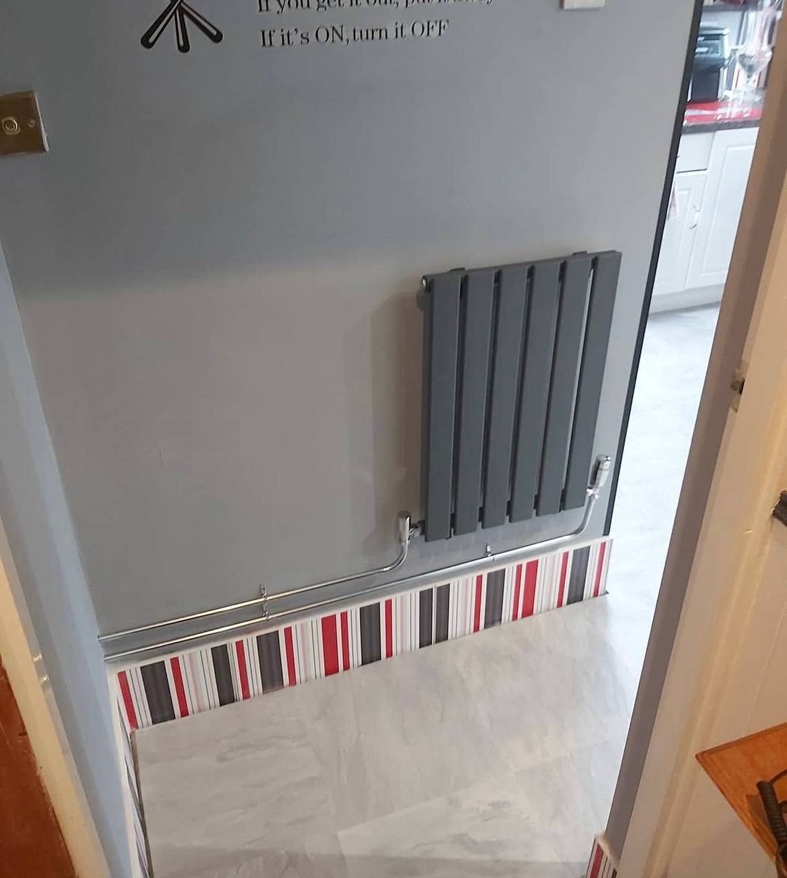 Anthracite flat panel radiator with chrome pipework fitted in a hallway